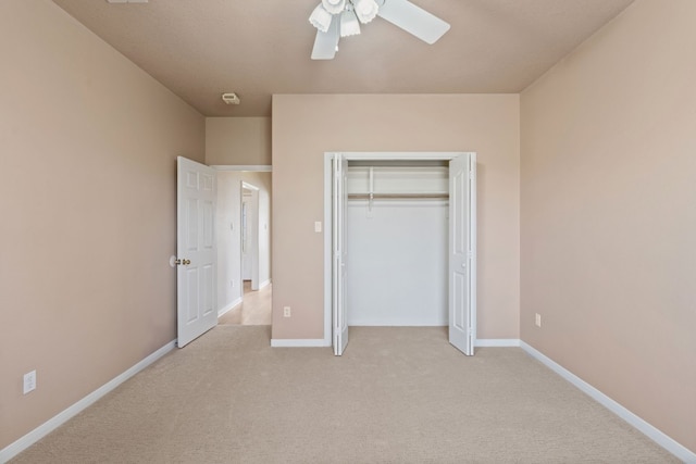 unfurnished bedroom featuring light colored carpet, ceiling fan, and a closet