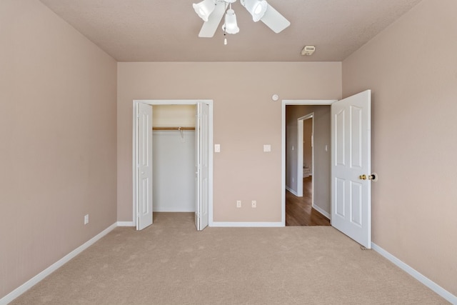 unfurnished bedroom featuring light carpet, ceiling fan, and a closet