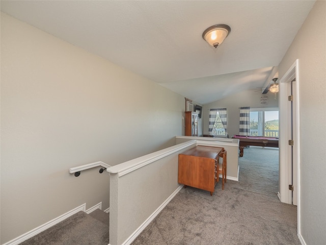 hall featuring carpet flooring and vaulted ceiling