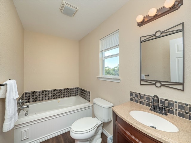 bathroom featuring vanity, a tub, wood-type flooring, backsplash, and toilet