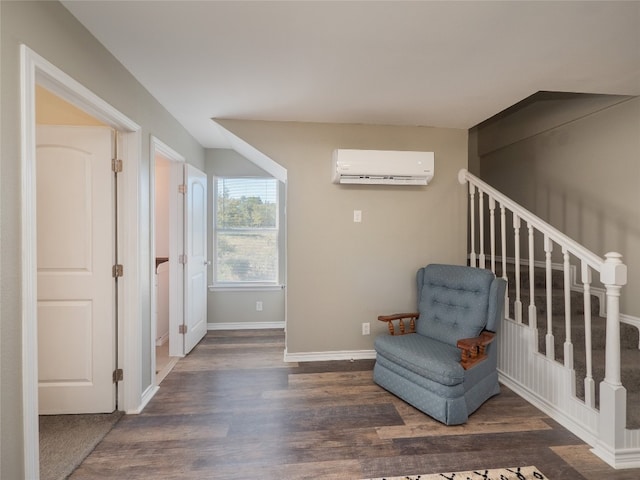 sitting room with dark hardwood / wood-style floors and a wall unit AC