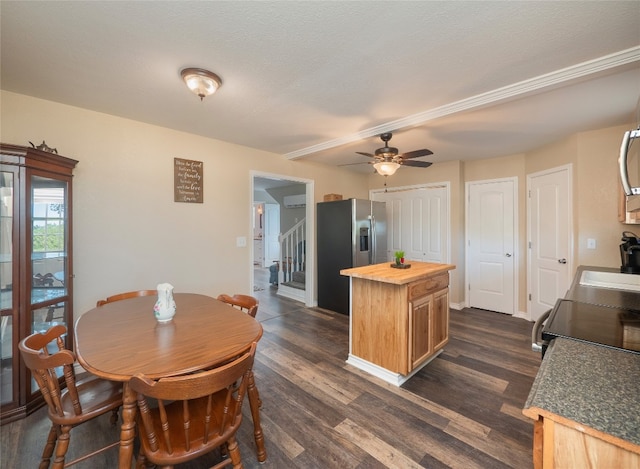 dining area with ceiling fan, dark wood-type flooring, and a textured ceiling