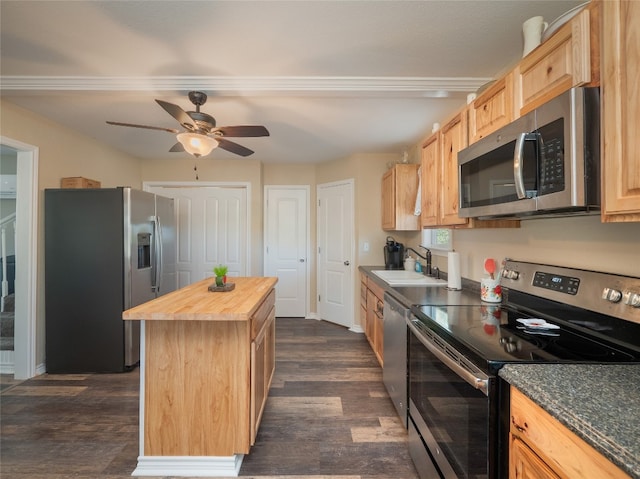 kitchen featuring butcher block counters, light brown cabinets, stainless steel appliances, a center island, and dark hardwood / wood-style floors