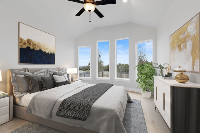 bedroom with lofted ceiling, light wood-type flooring, and a ceiling fan