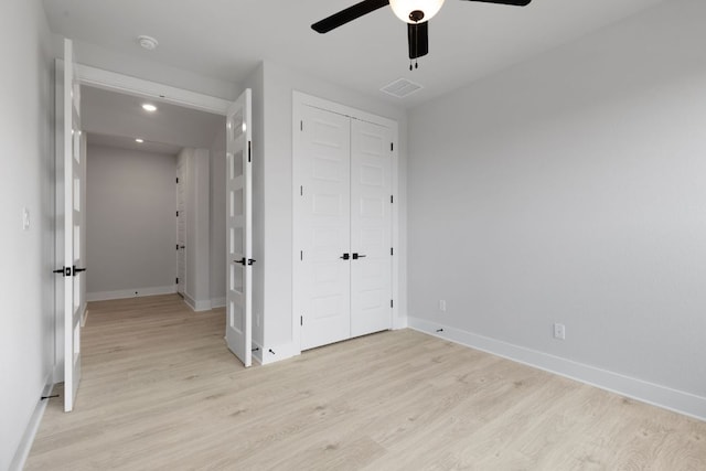 unfurnished bedroom featuring light wood finished floors, baseboards, visible vents, a closet, and recessed lighting