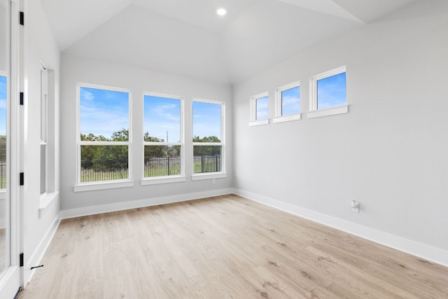 empty room with light wood-style floors, recessed lighting, vaulted ceiling, and baseboards