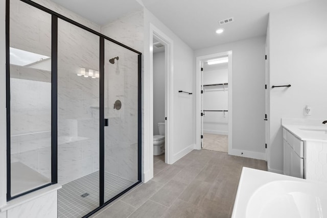 full bath with toilet, a stall shower, visible vents, and baseboards