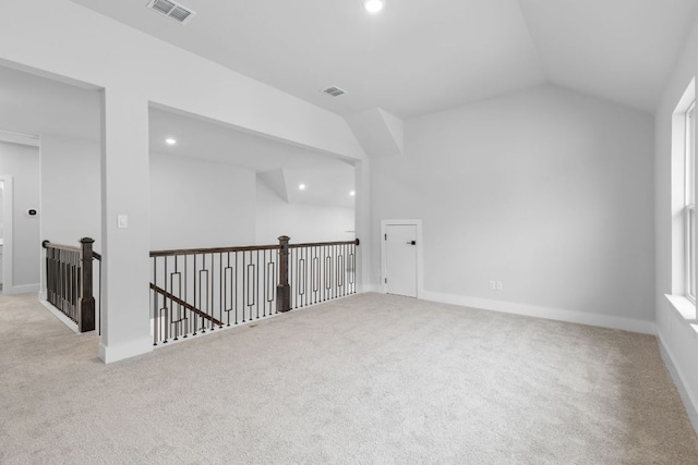 carpeted spare room featuring baseboards, visible vents, vaulted ceiling, and recessed lighting