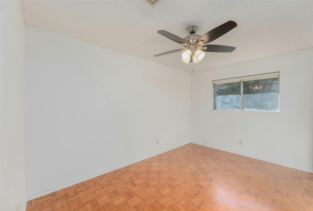 empty room with light parquet flooring and ceiling fan