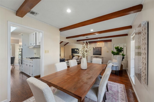 dining area with beamed ceiling and dark hardwood / wood-style flooring