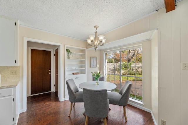 dining room featuring a chandelier, a textured ceiling, and dark hardwood / wood-style flooring