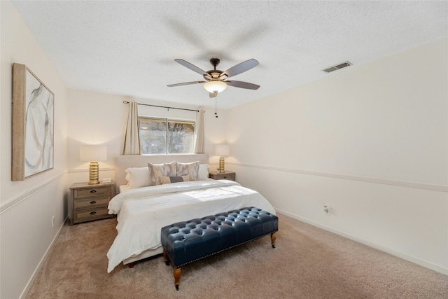 bedroom featuring a textured ceiling, carpet floors, and ceiling fan