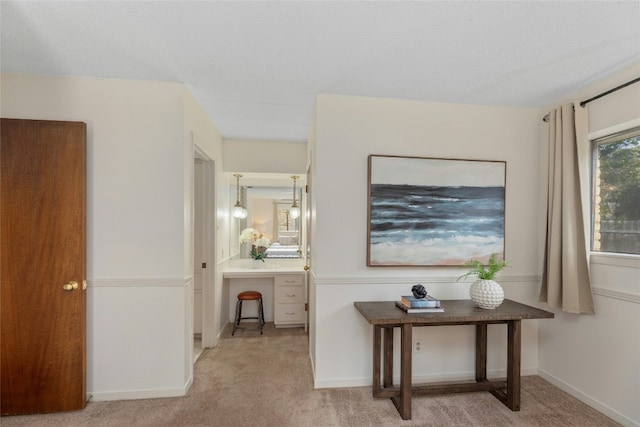 hall with light colored carpet