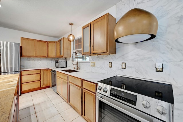 kitchen featuring appliances with stainless steel finishes, light tile patterned floors, sink, and pendant lighting