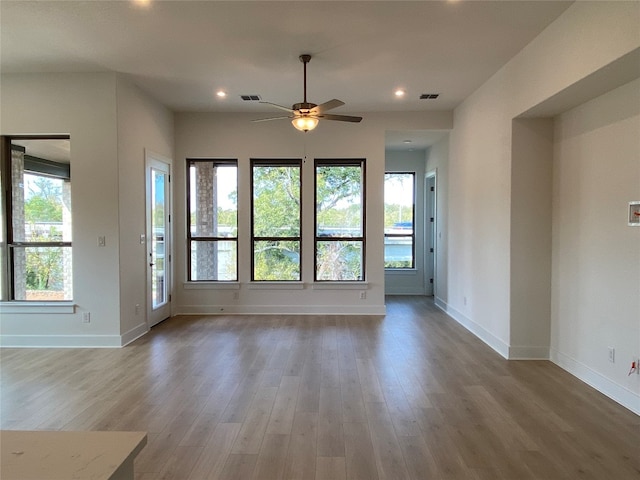 unfurnished living room with hardwood / wood-style flooring and ceiling fan