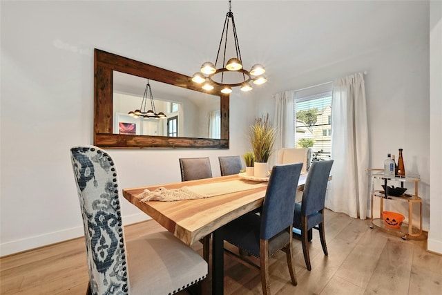 dining room with light hardwood / wood-style flooring and a chandelier