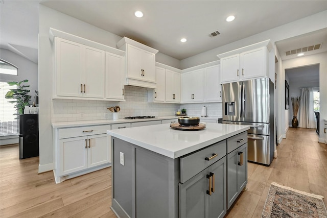 kitchen featuring gray cabinetry, white cabinets, appliances with stainless steel finishes, and plenty of natural light