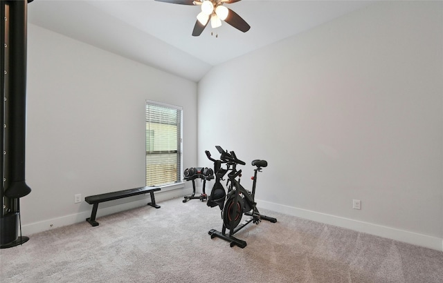 exercise room featuring ceiling fan, light carpet, and vaulted ceiling