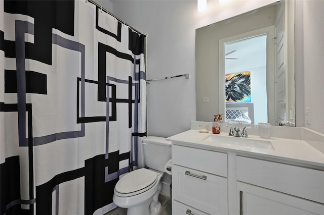 bathroom with curtained shower, vanity, and toilet