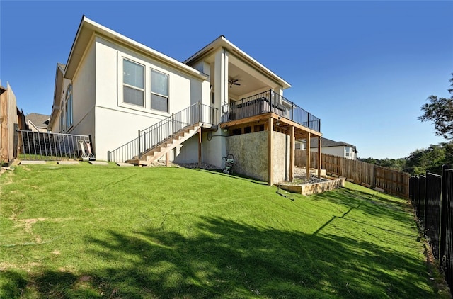 rear view of property with a lawn and ceiling fan