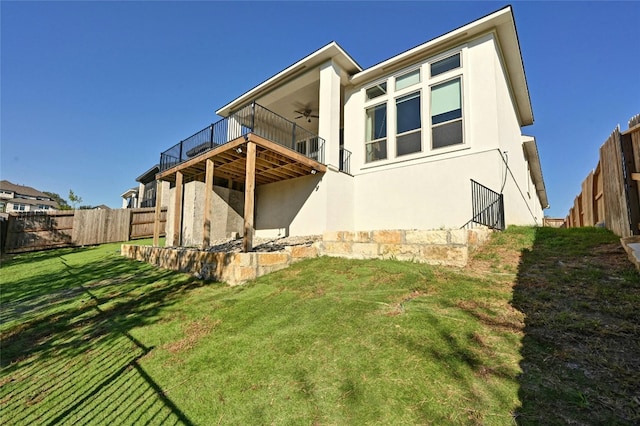 back of property featuring ceiling fan and a yard