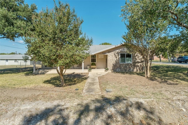 702 S Groos St, Kyle, TX 78640 - view of front of property featuring metal roof and a front lawn