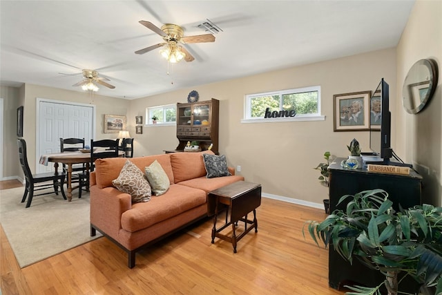 702 S Groos St, Kyle, TX 78640 - living area featuring light wood-style flooring, a ceiling fan, and baseboards