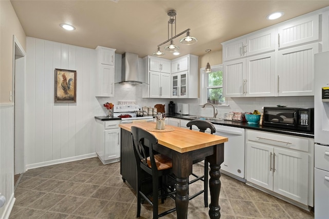 702 S Groos St, Kyle, TX 78640 - kitchen featuring wall chimney exhaust hood, a sink, white cabinetry, decorative backsplash, and white appliances