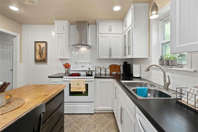 kitchen with white cabinets, white electric range, decorative light fixtures, sink, and wall chimney range hood