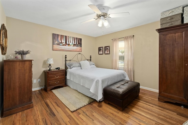 702 S Groos St, Kyle, TX 78640 - bedroom with wood finished floors, baseboards, and a ceiling fan