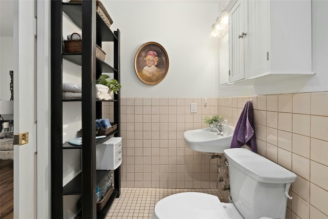 702 S Groos St, Kyle, TX 78640 - bathroom featuring tile walls, a wainscoted wall, a sink, and toilet