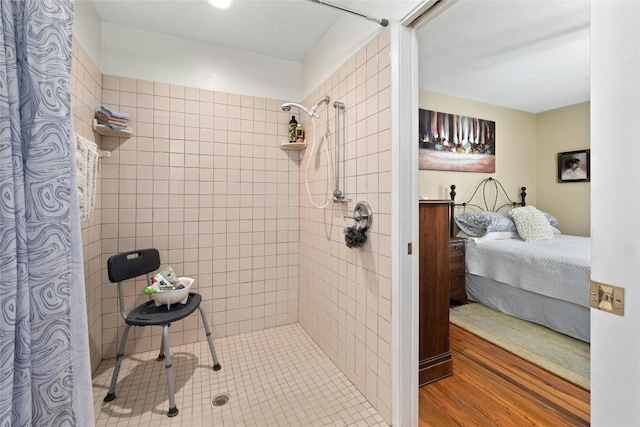 bathroom featuring wood-type flooring and a tile shower