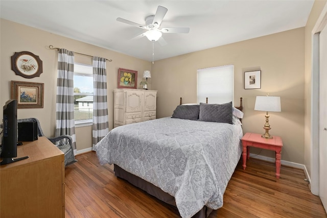 702 S Groos St, Kyle, TX 78640 - bedroom featuring wood finished floors, a ceiling fan, and baseboards