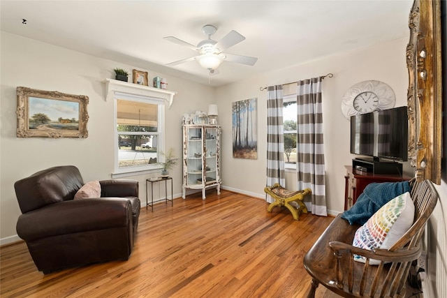 sitting room with ceiling fan and hardwood / wood-style flooring