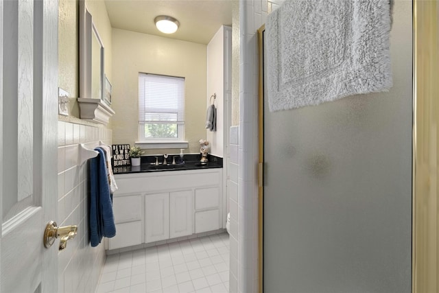 702 S Groos St, Kyle, TX 78640 - bathroom with a shower stall, tile patterned flooring, and vanity