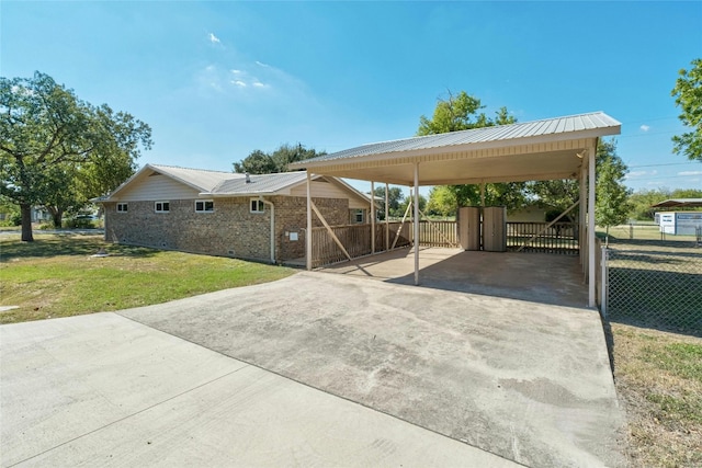 702 S Groos St, Kyle, TX 78640 - view of car parking with driveway, fence, and a detached carport