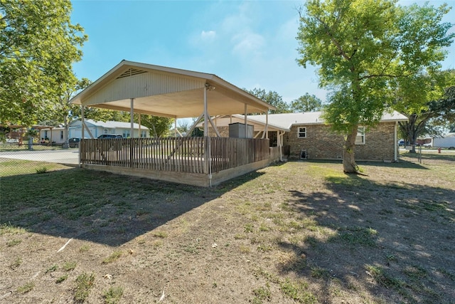 702 S Groos St, Kyle, TX 78640 - back of house featuring a detached carport and fence