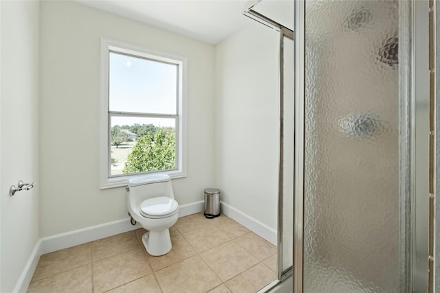 bathroom with tile patterned flooring, toilet, a healthy amount of sunlight, and walk in shower