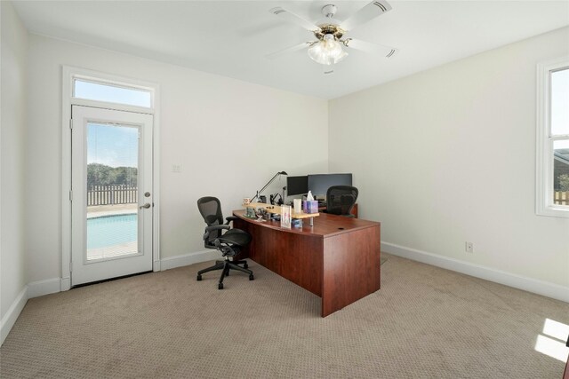 office space with light carpet and ceiling fan