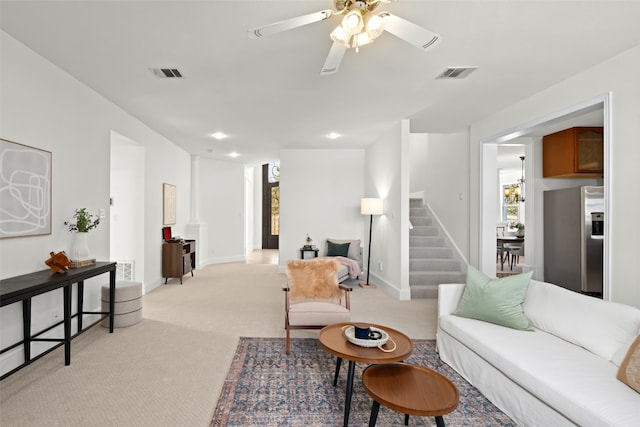 living room featuring ceiling fan, a wealth of natural light, and light colored carpet