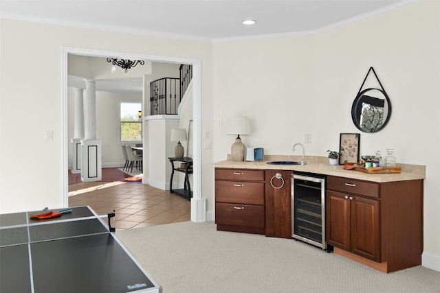 bar with wine cooler, crown molding, light carpet, and ornate columns