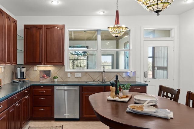 kitchen with tasteful backsplash, light tile patterned floors, dishwasher, sink, and decorative light fixtures