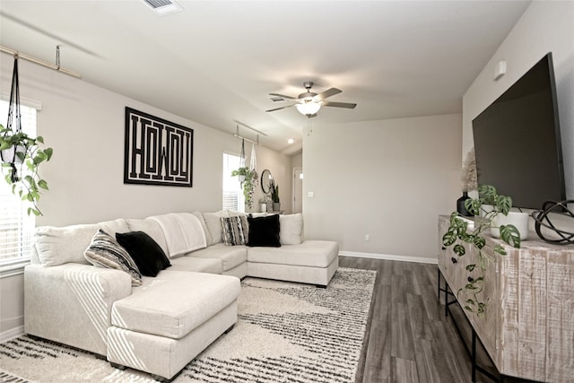 living room with dark wood-type flooring and ceiling fan