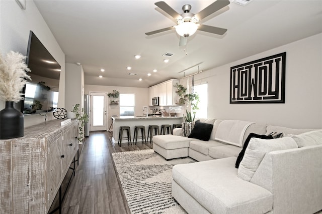 living room with ceiling fan, dark hardwood / wood-style floors, and sink