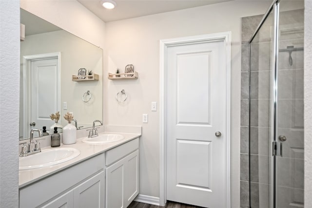 bathroom featuring hardwood / wood-style flooring, vanity, and an enclosed shower