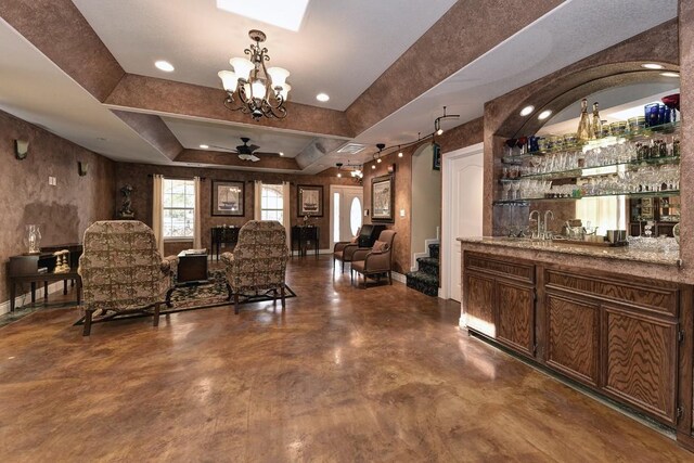 4525 Bell Springs Rd, Dripping Springs, TX 78620 - bar featuring ceiling fan with notable chandelier, wet bar, a sink, a raised ceiling, and baseboards