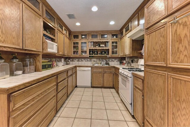 4525 Bell Springs Rd, Dripping Springs, TX 78620 - kitchen with tile countertops, white appliances, visible vents, light tile patterned flooring, and a sink