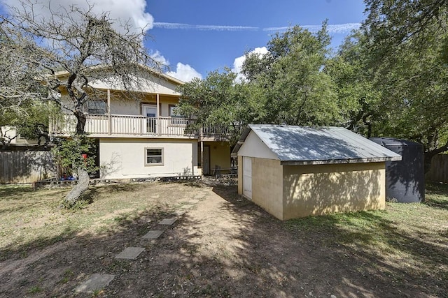 4525 Bell Springs Rd, Dripping Springs, TX 78620 - rear view of property featuring a balcony, an outdoor structure, stucco siding, a storage shed, and fence