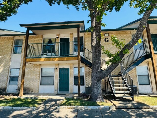 1624 Aquarena Springs Dr Unit G154, San Marcos, TX 78666 - view of front of property featuring a balcony, stairway, and brick siding