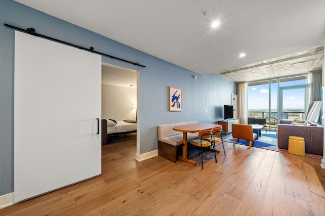 48 E Ave Unit 2511, Austin, TX 78701 - dining room with a barn door, light wood finished floors, a wall of windows, baseboards, and recessed lighting